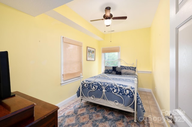 tiled bedroom with baseboards and a ceiling fan
