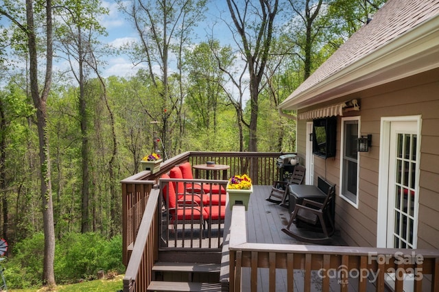 wooden terrace featuring a wooded view and cooling unit