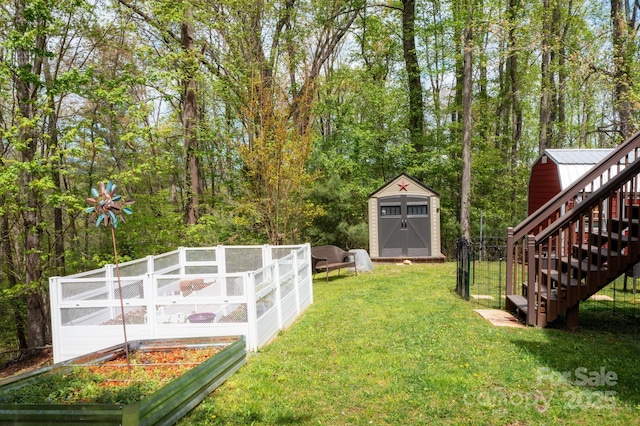 view of yard featuring an outdoor structure, a garden, a shed, and stairs