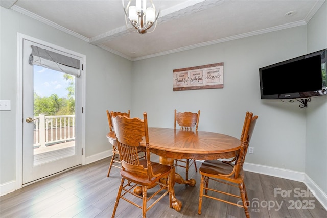 dining space featuring crown molding, wood finished floors, and baseboards