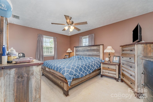 bedroom featuring visible vents, ceiling fan, and carpet