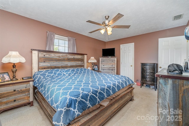 carpeted bedroom with visible vents and a ceiling fan