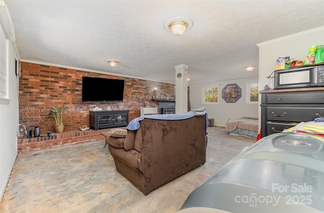 living area featuring brick wall, a wood stove, a textured ceiling, and crown molding