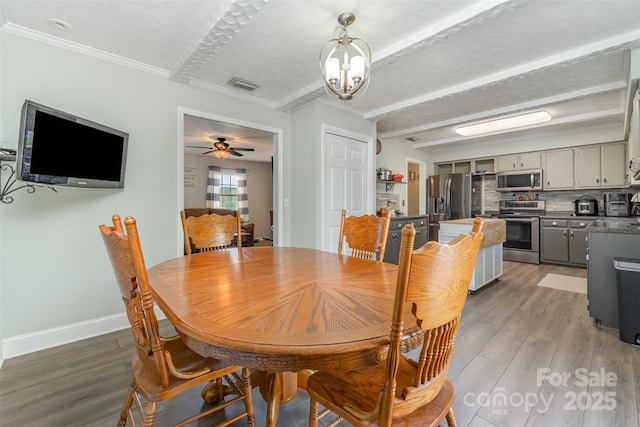 220 Hilltop St, Connelly Springs, NC 28612 - dining space with light wood-style floors, crown molding, baseboards, a chandelier, and beam ceiling