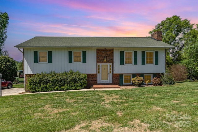 220 Hilltop St, Connelly Springs, NC 28612 - split foyer home with a chimney, a yard, brick siding, and roof with shingles