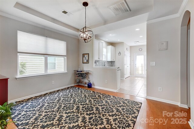 13610 Aldenbrook Dr, Huntersville, NC 28078 - dining room featuring healthy amount of natural light, a tray ceiling, arched walkways, crown molding, and recessed lighting