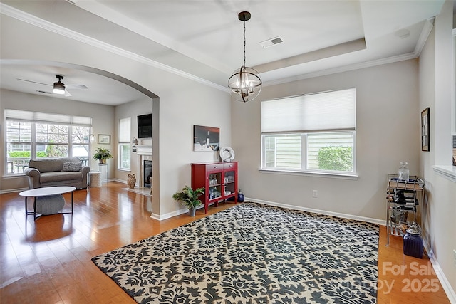 13610 Aldenbrook Dr, Huntersville, NC 28078 - sitting room featuring wood finished floors, a tile fireplace, a ceiling fan, baseboards, and arched walkways