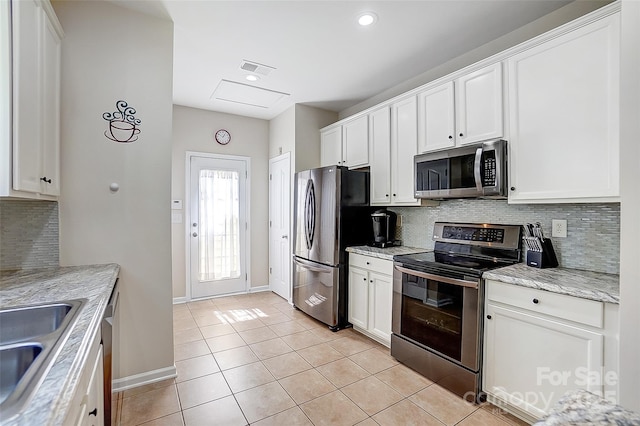 13610 Aldenbrook Dr, Huntersville, NC 28078 - kitchen featuring appliances with stainless steel finishes, light tile patterned floors, a sink, baseboards, and tasteful backsplash