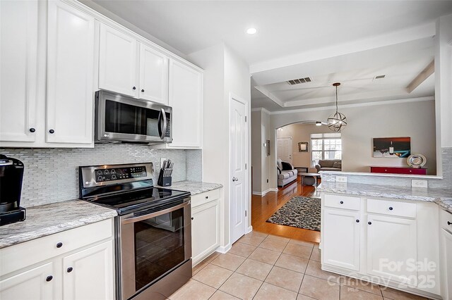 13610 Aldenbrook Dr, Huntersville, NC 28078 - kitchen with appliances with stainless steel finishes, arched walkways, light tile patterned floors, white cabinetry, and decorative backsplash