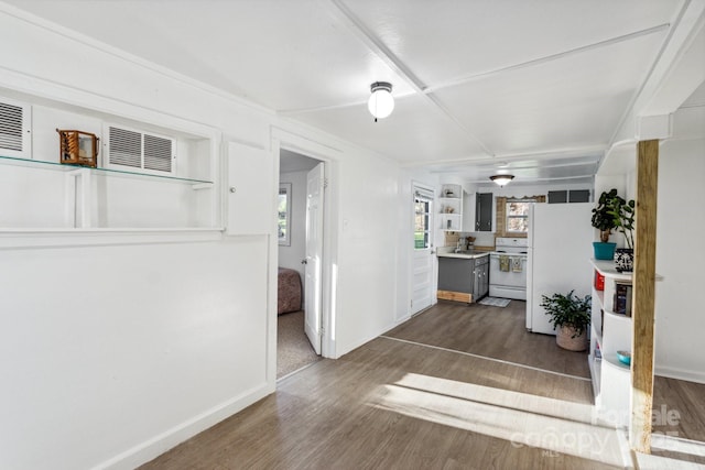 unfurnished living room with wood finished floors and baseboards