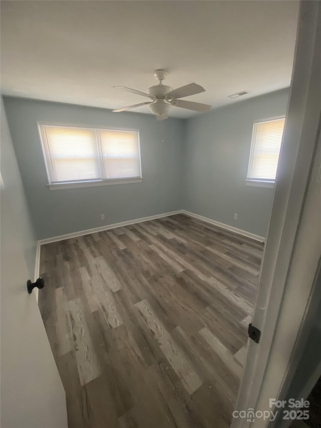 unfurnished room featuring visible vents, ceiling fan, baseboards, and wood finished floors