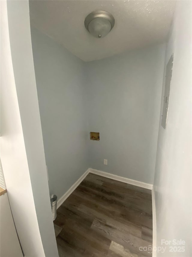 laundry area with wood finished floors, baseboards, hookup for a washing machine, and electric panel