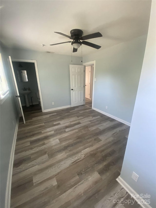 unfurnished bedroom with dark wood-type flooring and baseboards