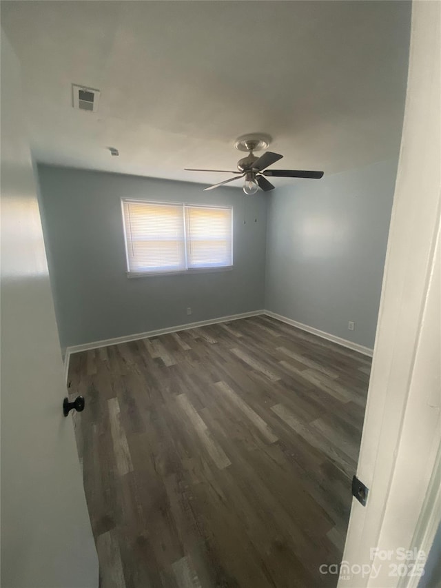 empty room featuring visible vents, ceiling fan, baseboards, and dark wood-style floors