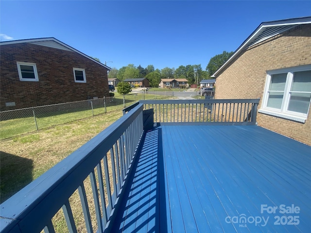wooden terrace with a yard, a residential view, and a fenced backyard