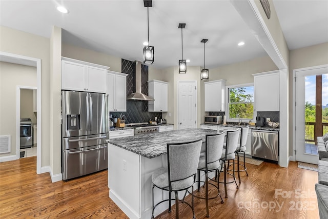 44 Sycamore Dr, Nebo, NC 28761 - kitchen featuring wall chimney range hood, a center island, appliances with stainless steel finishes, and backsplash