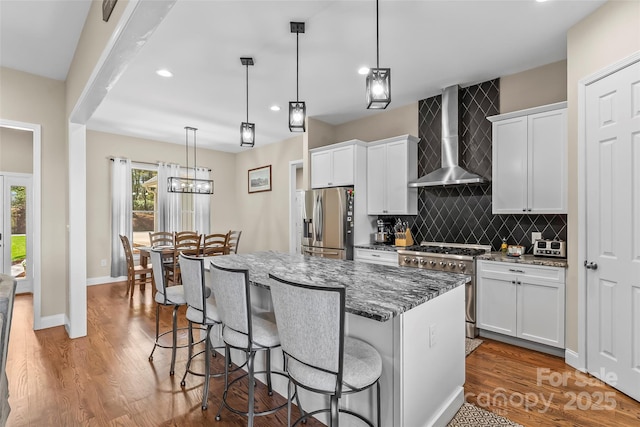 44 Sycamore Dr, Nebo, NC 28761 - kitchen featuring tasteful backsplash, wall chimney exhaust hood, a kitchen bar, stainless steel appliances, and a kitchen island