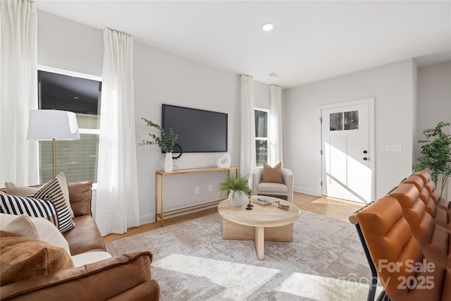 living room featuring recessed lighting, baseboards, and wood finished floors