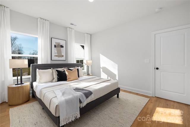 bedroom with visible vents and wood finished floors