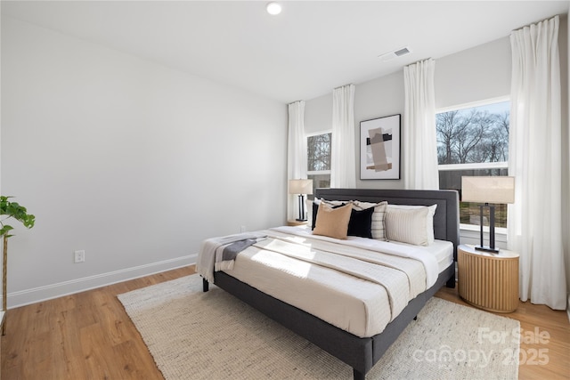 bedroom featuring visible vents, baseboards, and light wood-type flooring