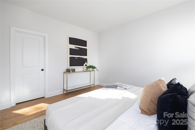 bedroom with wood finished floors and baseboards
