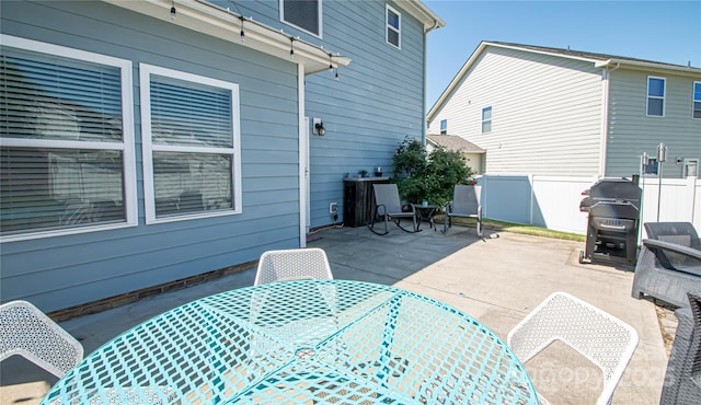 view of patio with fence, a grill, and outdoor dining space