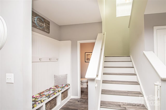 staircase featuring baseboards and wood finished floors