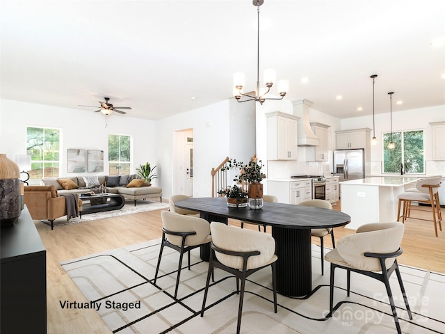 2501 Elon St, Charlotte, NC 28208 - dining area with light wood-style flooring, a ceiling fan, and a chandelier