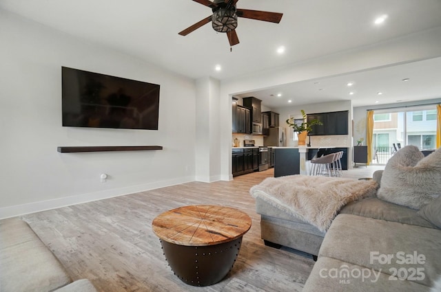 living room featuring recessed lighting, baseboards, a ceiling fan, and light wood finished floors