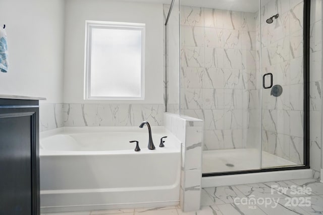 full bathroom featuring a bath, marble finish floor, and a stall shower