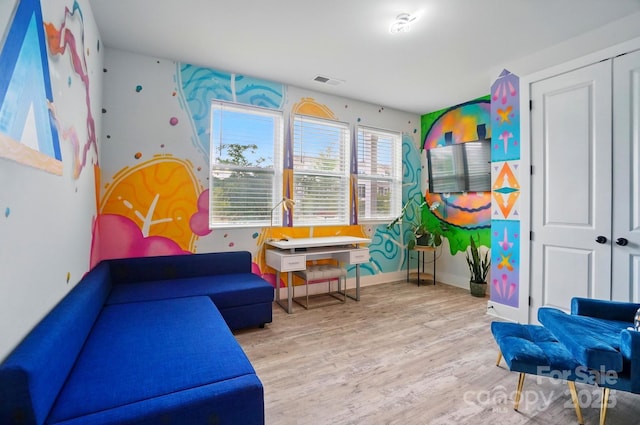 playroom featuring baseboards, wood finished floors, and visible vents