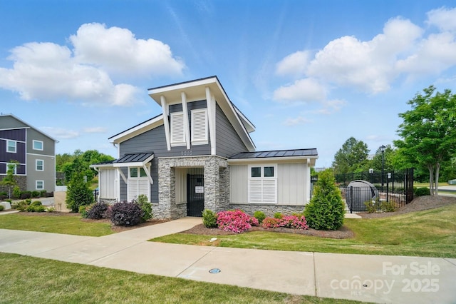 2533 Ensemble Ct, Charlotte, NC 28262 - view of front facade with fence, stone siding, a standing seam roof, board and batten siding, and metal roof
