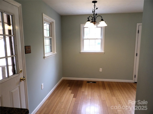 106 Pinetree Dr, Black Mountain, NC 28711 - unfurnished dining area featuring a healthy amount of sunlight, baseboards, a chandelier, and light wood-style floors