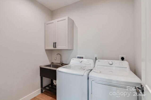 175 Silverglen Way, Hendersonville, NC 28792 - washroom with cabinet space, a sink, light wood-style flooring, baseboards, and washer and clothes dryer