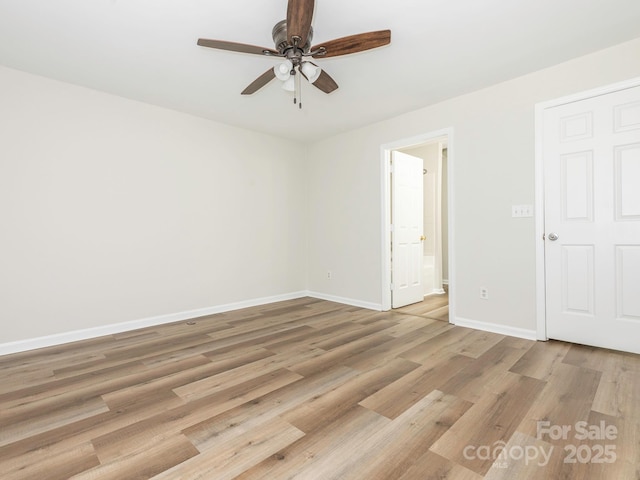 unfurnished bedroom featuring light wood-style floors, baseboards, a ceiling fan, and ensuite bathroom