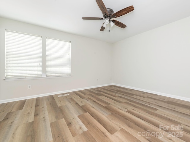 spare room with ceiling fan, baseboards, and visible vents