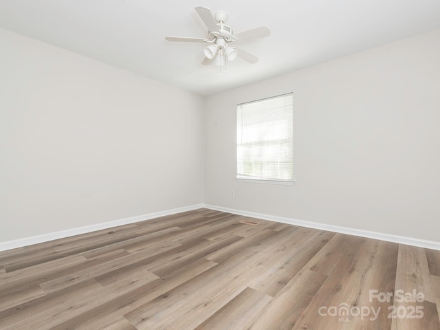 unfurnished room with baseboards, wood finished floors, and ceiling fan