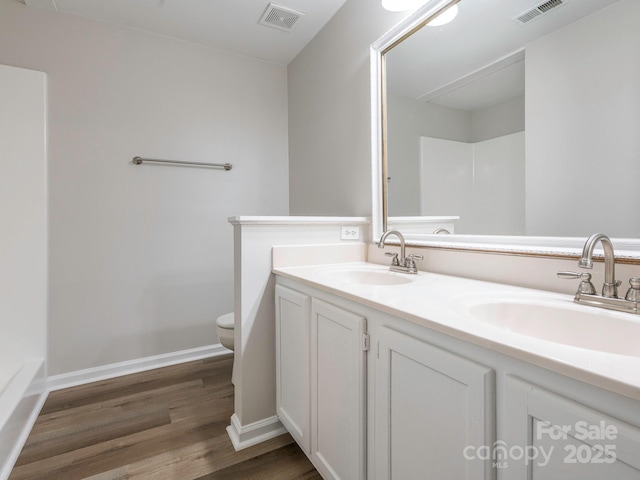 full bathroom with visible vents, a sink, and wood finished floors