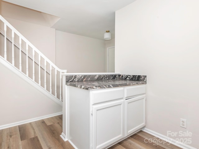 stairway featuring baseboards and wood finished floors