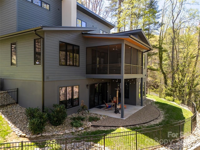 back of house featuring a patio area, a sunroom, and a fenced backyard