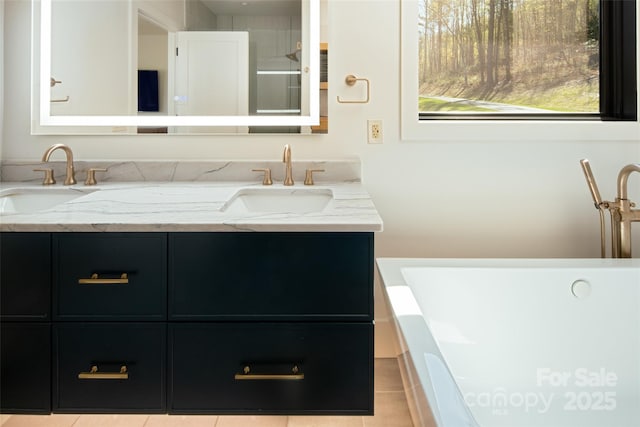 bathroom featuring double vanity, a sink, a freestanding tub, and tile patterned floors