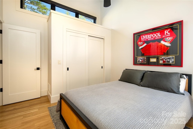 bedroom with light wood finished floors and a closet