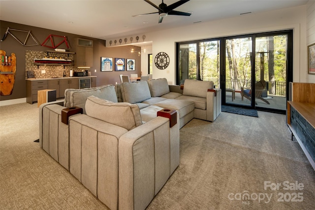 living area with light colored carpet, visible vents, indoor bar, wine cooler, and a ceiling fan