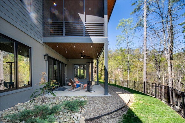 view of yard with a patio, a ceiling fan, a balcony, and fence