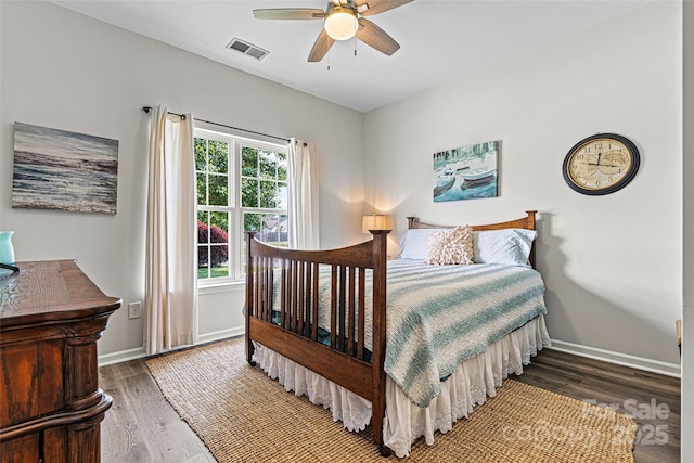 bedroom with visible vents, baseboards, and wood finished floors