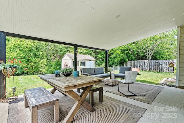 view of patio / terrace featuring fence, a storage shed, an outbuilding, outdoor dining area, and an outdoor living space