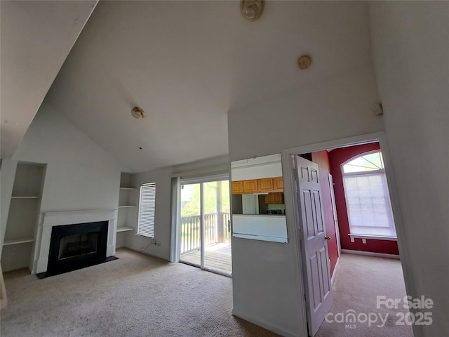 2527 Carya Pond Ln, Charlotte, NC 28212 - unfurnished living room featuring a fireplace with flush hearth, light carpet, high vaulted ceiling, and plenty of natural light
