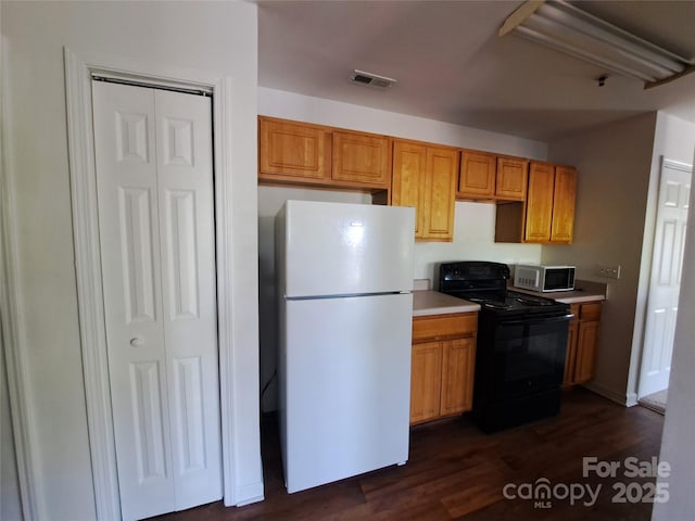 2527 Carya Pond Ln, Charlotte, NC 28212 - kitchen featuring black / electric stove, dark wood-style floors, light countertops, freestanding refrigerator, and visible vents