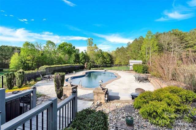 view of swimming pool featuring fence, a patio area, and a fenced in pool
