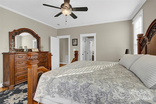 bedroom with a ceiling fan, crown molding, wood finished floors, baseboards, and visible vents